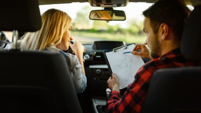 Instructor helps woman to drive the car