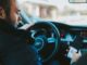 person holding and staring a phone at the wheel of an audi vehicle.jpg